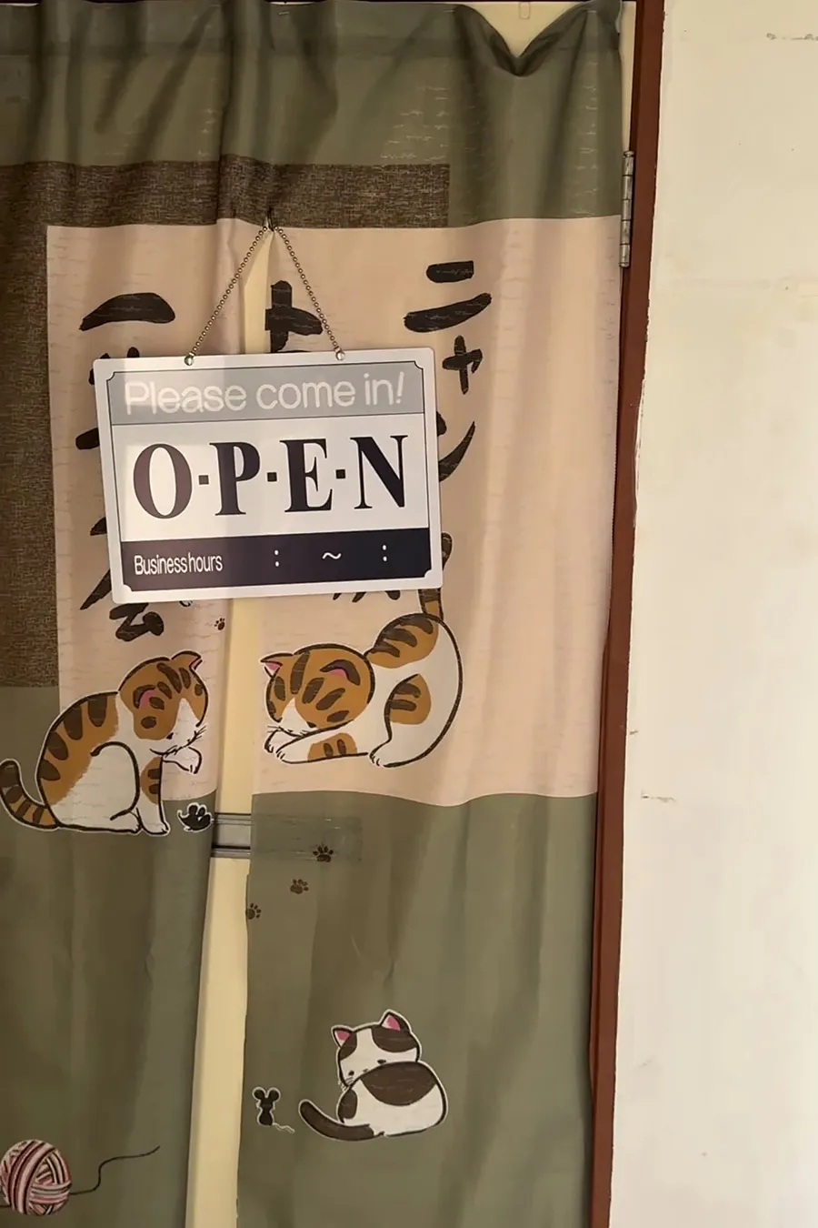 ねこ柄ののれんがかかったお店の入口