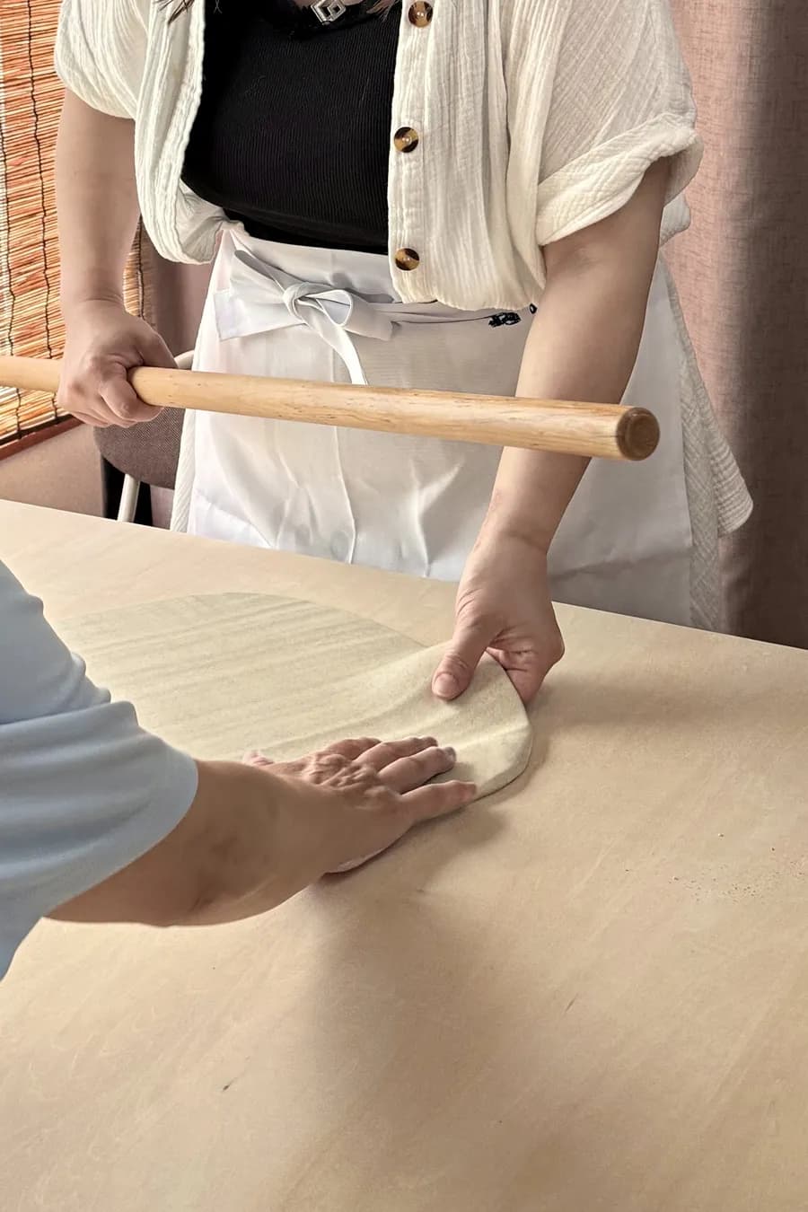 教わりながら麺棒で生地をのばしている様子